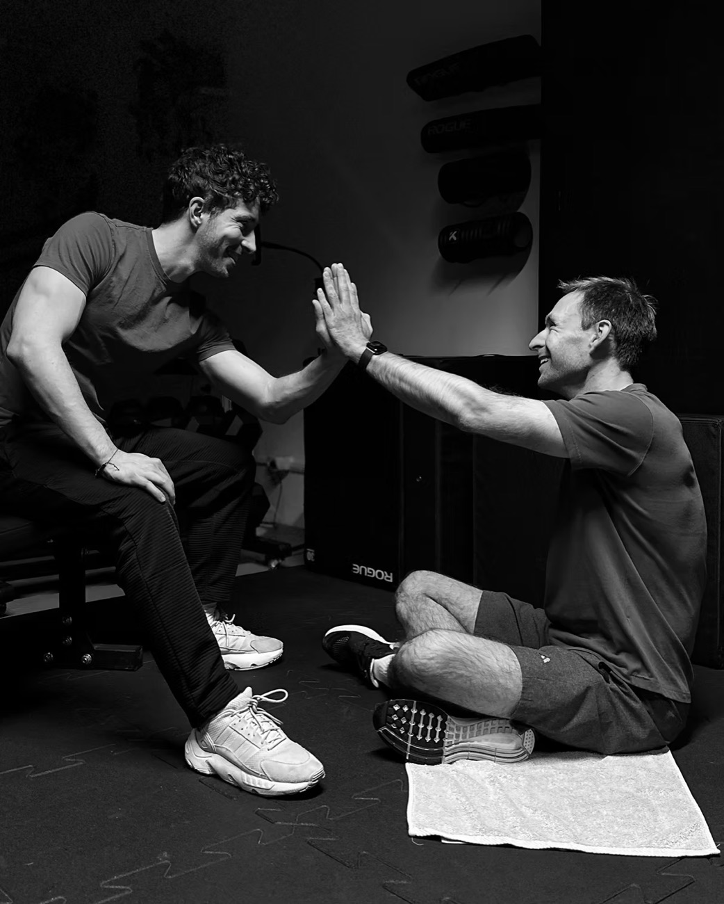 Vítek Korinek klatscht mit einem Kunden im Fitness First Berlin ab